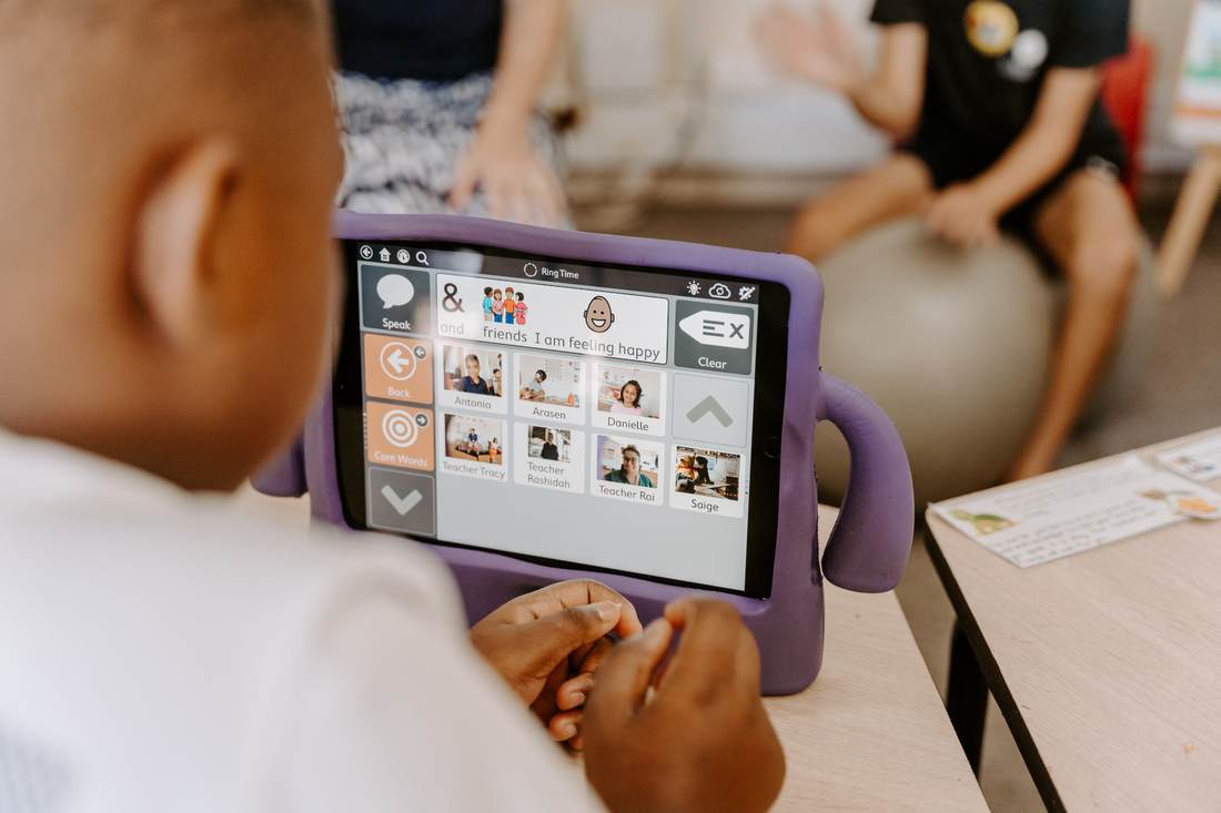 A child using an AAC tablet during ring time