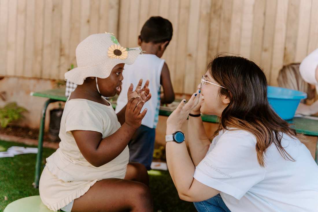 A teacher and child signing to each other