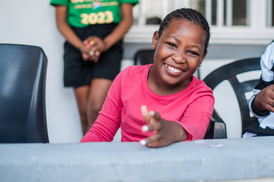 A child smiling at a table