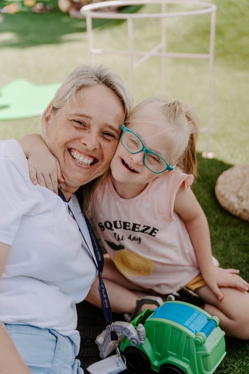 A teacher and child sitting together in the garden